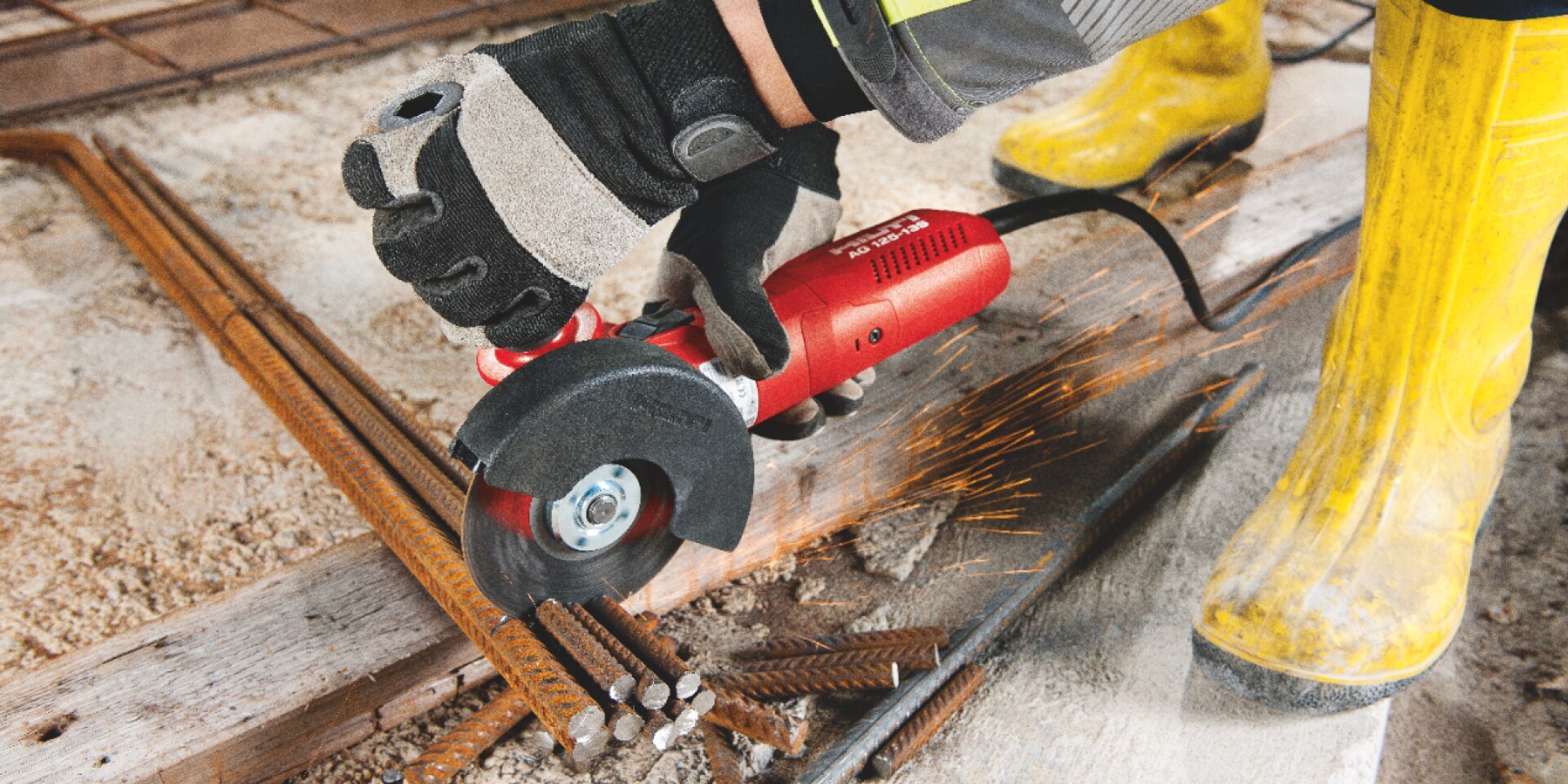Construction worker using an angle grinder to cut rebar
